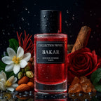 Der luxuriöse Glasflakon von Collection Privée Bakar mit roter Flüssigkeit, stimmungsvoll umgeben von Safran, weißen Blüten, Rosen, Mandeln und Amber vor dunklem Hintergrund.