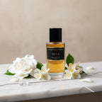Das Collection Privée Mula 50ml Unisex Parfum elegant arrangiert auf hellem Stein, umgeben von frischen, zarten weißen Blüten.