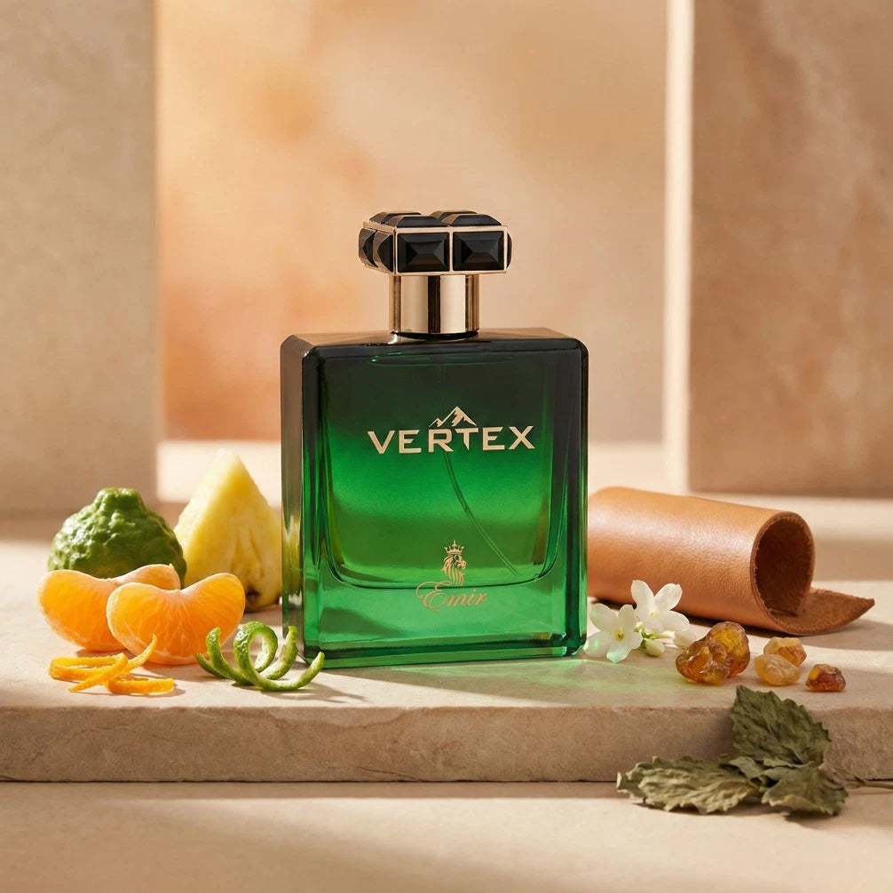 Der smaragdgrüne Glasflakon von Emir Vertex, appetitlich arrangiert mit frischer Mandarine, Ananas, Zitrusfrüchten und eleganten Lederrollen.