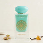 Der mintgrüne Glasflakon von Gulf Orchid Musk Collection Pistachio, elegant umgeben von echten Pistazien, Vanilleschoten und Bernstein auf einer hellen Steinplatte.