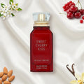 Der leuchtend rote Glasflakon von Gulf Orchid Sweet Cherry Kiss, elegant präsentiert auf weißem Seidenstoff, umgeben von frischen Kirschen, Mandeln, Vanille und weißen Blüten.