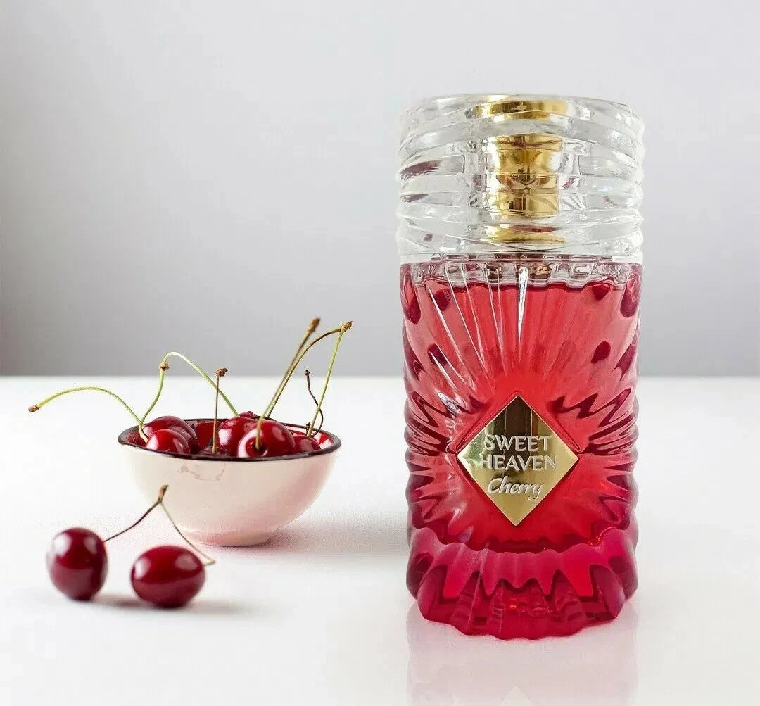 Der leuchtend rote, aufwendig geschliffene Glasflakon von Gulf Orchid Sweet Heaven Cherry, elegant arrangiert mit frischen, saftigen Kirschen in einer Schale.
