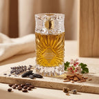 Der aufwendig geschliffene Glasflakon von Gulf Orchid Sweet Heaven Extreme, elegant präsentiert auf einer Steinplatte, umgeben von Kaffeebohnen, Lavendel, Tonkabohne und Geranienblüten.