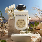 Der weiße Glasflakon von Gulf Orchid Tahara Vanilla mit goldenem Mandala, romantisch umgeben von weißen Blüten im sanften, warmen Sonnenlicht.