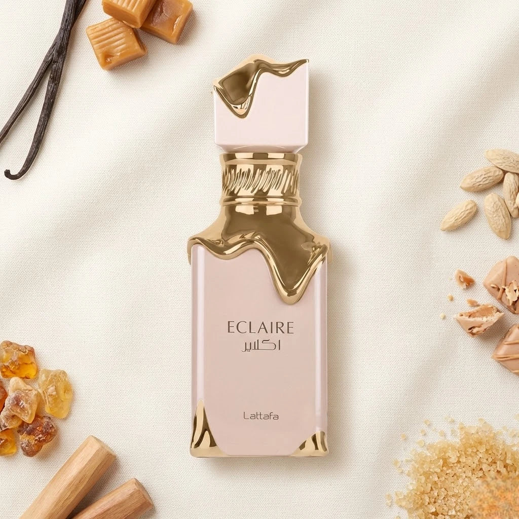 Der rosa Flakon von Lattafa Eclaire mit fließendem Gold-Design, appetitlich umgeben von Karamell, Vanilleschoten und braunem Zucker.