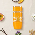 Der leuchtend orangefarbene Flakon von Lattafa Yara Tous, tropisch umgeben von saftiger Mango, Kokosnuss, Passionsfrucht und weißen Blüten.